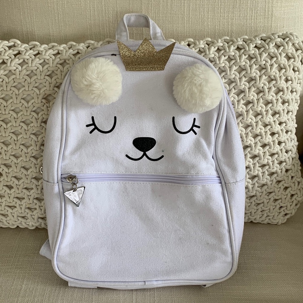 Guess girls small backpack with faux poofs and glitter crown detail.